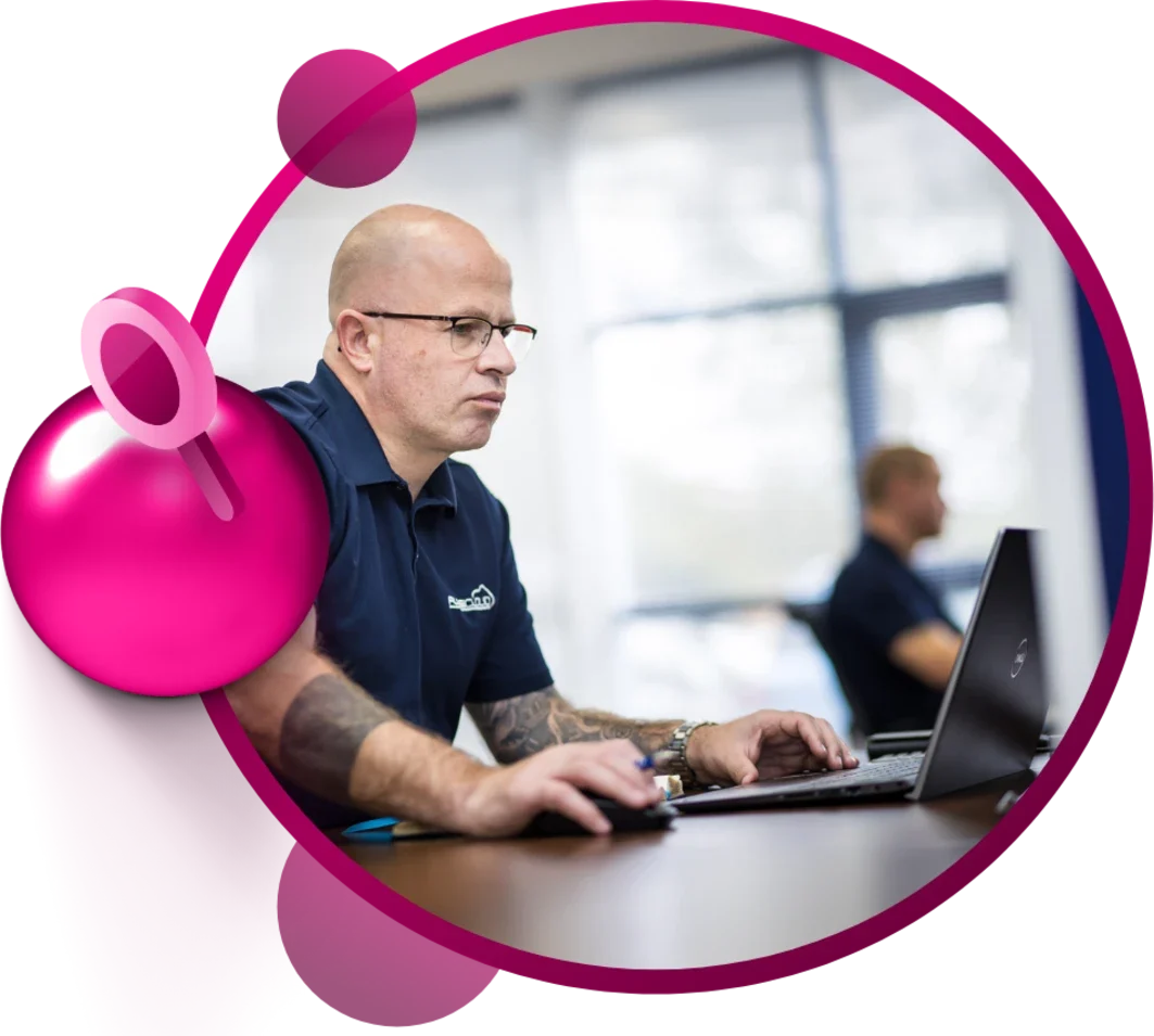A person working on a laptop with a mouse, wearing a navy blue shirt.