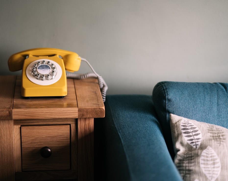 Yellow landline telephone on a side table, representing legacy ISDN phones