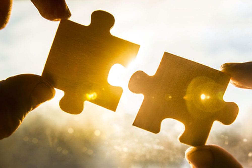 Two puzzle pieces being joined together