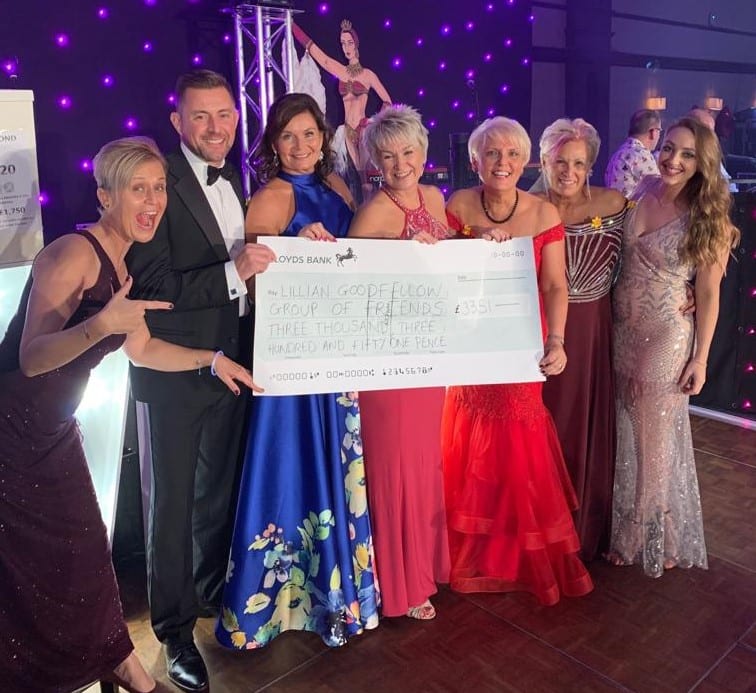 Photo taken during the Pink Ball initiative with a group of people holding the donation check